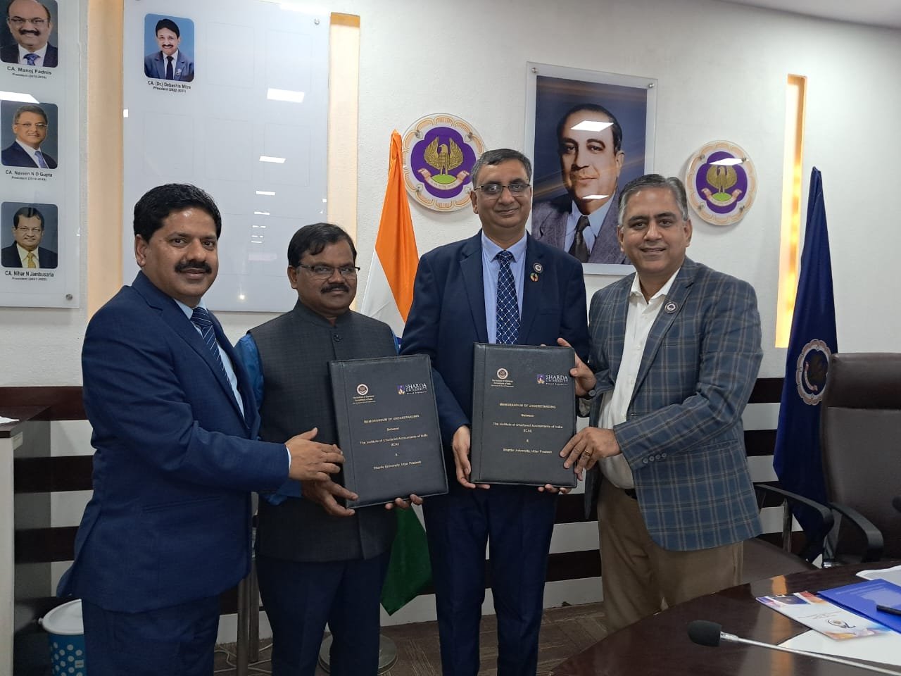 A formal institutional collaboration moment at Sharda University.