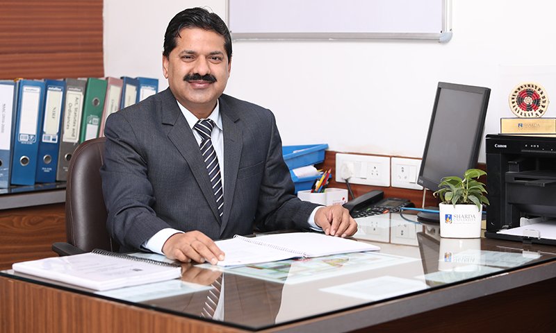 Founder of HEO Excellence Advisory seated at a desk in an office